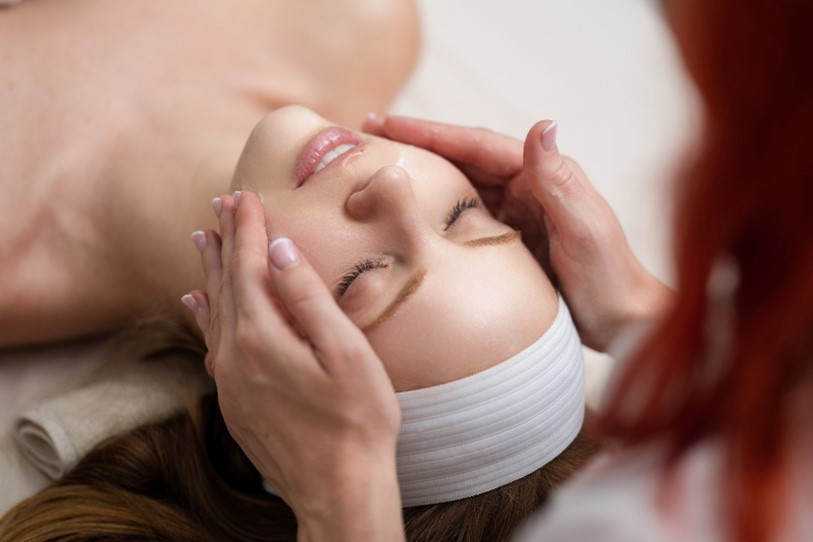 A woman wearing a white headband receives a classic facial from a skilled esthetician.